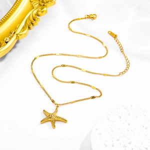Close-up of golden starfish pendant with crystal center and textured metal finish