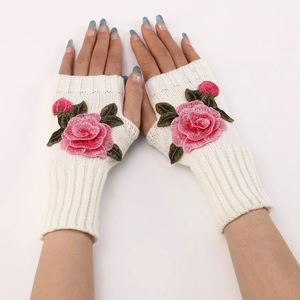Close-up of cream knit fingerless gloves featuring pink rose embroidery and leaf detail