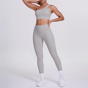 Detail of light grey one-shoulder sports bra and high-waisted yoga leggings set