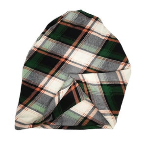 Detailed knit texture of green and black plaid beanie with subtle orange accents