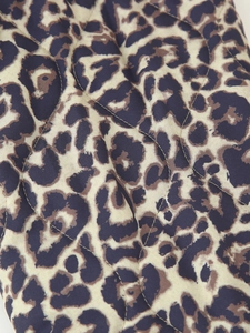 Detail of leopard print quilted jacket with wavy stitching and textured padding