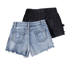 Close-up of ripped denim shorts back pockets with distressed details and frayed hems