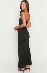 Vista laterale dell'abito lungo nero a fascia con taglio slim ed elegante silhouette