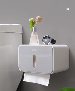 Detail of wall-mounted gray tissue box with top storage shelf and viewing window