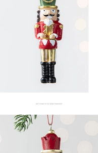 Detail view of a resin Nutcracker drummer ornament with red lanyard for Christmas tree decor