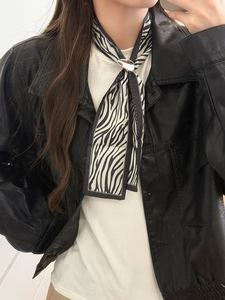 Close-up of zebra pattern silk scarf necklace with a silver oval buckle detail