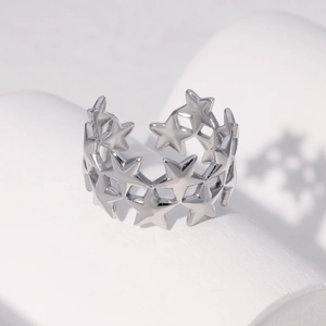 Macro-opname van zilveren open ring met holle sterpatronen op een minimalistische steen