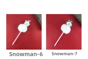 Close-up of Christmas pens with plush white balls and festive bear and snowman toppers