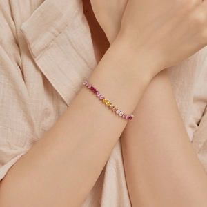Close-up of a gradient heart-shaped gemstone bracelet worn on a woman's wrist