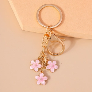 Detail of pink cherry blossom keychain charms with gold plating and enamel finish