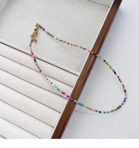 Dettaglio ravvicinato della collana di perline arcobaleno con chiusura dorata elegante