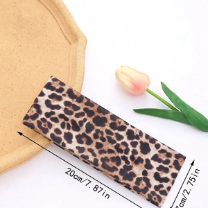 Detailed view of leopard print headband showing 20cm by 7cm dimensions and soft fabric