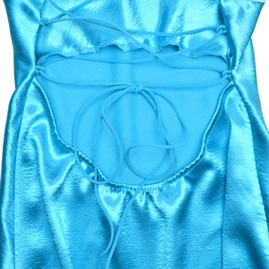Détail rapproché de la robe en satin bleu avec laçage croisé au dos et texture soyeuse