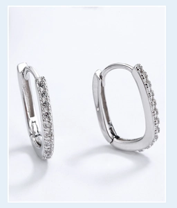 Macro detail of silver S925 huggie earrings with pave-set sparkling zircon stones