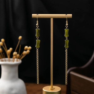 Detail of vintage Chinese style long tassel earrings with green bamboo beads and gold chain