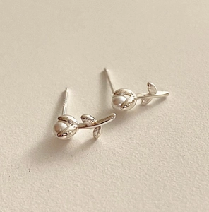 Détail macro de boucles d'oreilles tulipes en argent S925 avec perles blanches