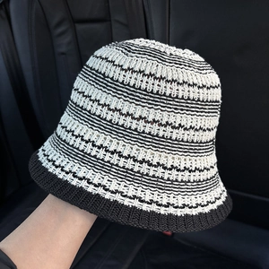 Detail of black and white striped hollow knit bucket hat with breathable texture