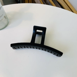 Macro shot of large black matte claw clip with curved teeth and square handle for thick hair