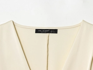 Vue détaillée du col en satin de soie beige avec décolleté en V et étiquette de taille de marque