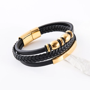 Détail d'un bracelet multicouche en cuir noir avec un fermoir magnétique doré