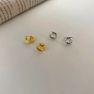 Minimalist S925 silver O-shaped hoop earrings in gold and silver finishes on a book