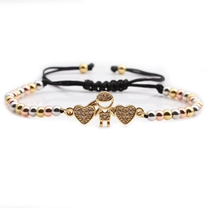 Three-tone gold beaded braided bracelet with heart and boy charms on white background