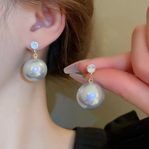 Détails des boucles d'oreilles papillon en perles et zircons avec finition dorée de luxe