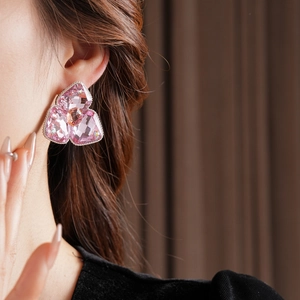 Detailed view of pink flower crystal earrings on model showing elegant diamond accents