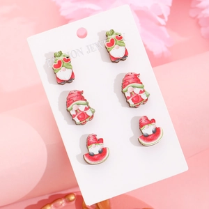 Detailed view of three pairs of cartoon gnome stud earrings on a white jewelry display card