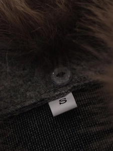 Close-up of the faux fur jacket texture, button detail, and S size label