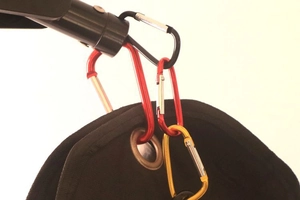 Close-up of colorful D-shaped aluminum carabiners hooked onto a black fabric bag
