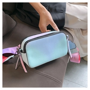 Detail of gradient crossbody camera bag featuring dual zippers and textured faux leather