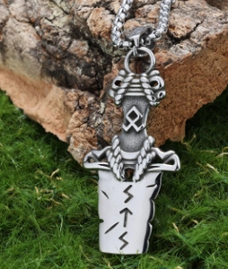 Dettaglio del ciondolo spada vichinga di Odino con rune su corteccia d'albero naturale