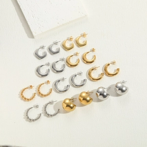 Minimalist geometric titanium steel earrings in gold and silver finish on white stone