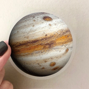 Close-up of a waterproof Jupiter planet sticker with detailed orange and brown surface texture