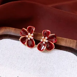 Elegant 18K gold-plated flower stud earrings with deep red enamel and white stones