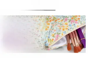 Detail view of smooth zipper and floral quilted cotton cosmetic bag with brushes