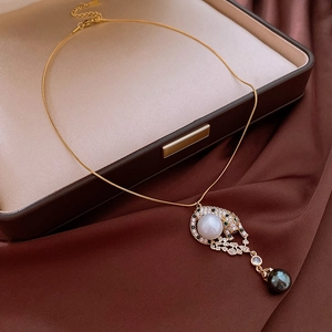 Detailed view of leopard pendant with pavé crystals and white and black pearls