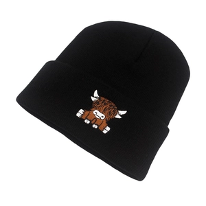 Detail of embroidered Highland Cow patch on a black ribbed knit beanie hat
