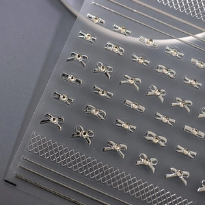 5D silver bow nail stickers with rhinestones and grid lines on grey background