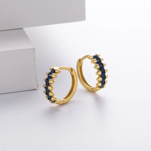 Macro detail of gold hoop earrings featuring rectangular blue sapphire zircon stones