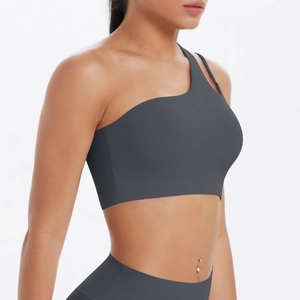 Detail of dark grey one-shoulder sports bra and high-waisted yoga leggings set