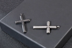 Macro detail of vintage cross pendants showing brushed metal texture and retro finish