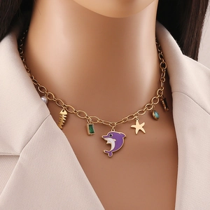 Gold ocean necklace featuring dolphin, starfish and colorful gemstones pendants on a model
