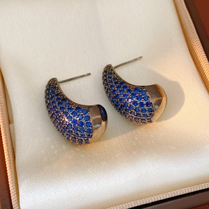Detail view of vintage silver earrings with blue zircon inlays in a gift box