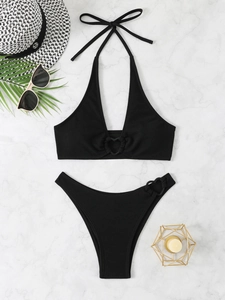 Set bikini nero a fascia con anelli a cuore e trama a coste su sfondo di marmo