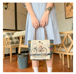 Lifestyle shot of an ethnic canvas tote with Penang street art and a woven strap