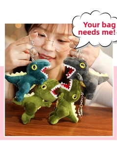 Close-up of colorful dinosaur plush keychains in blue, green, and grey with metal rings