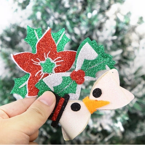 Close-up of festive Christmas hair clips featuring poinsettia, bow, and snowman designs