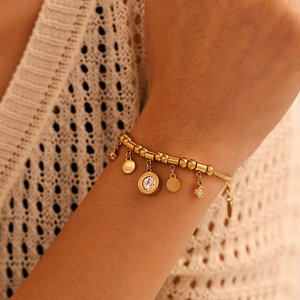 Gold Roman numeral charm bracelet with sparkling zircon fringe on a model's wrist